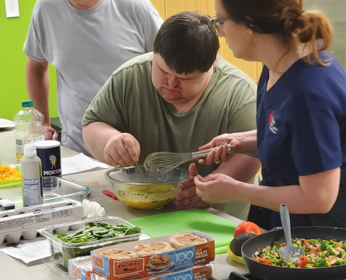 Client with down syndrome partakes in a cooking class